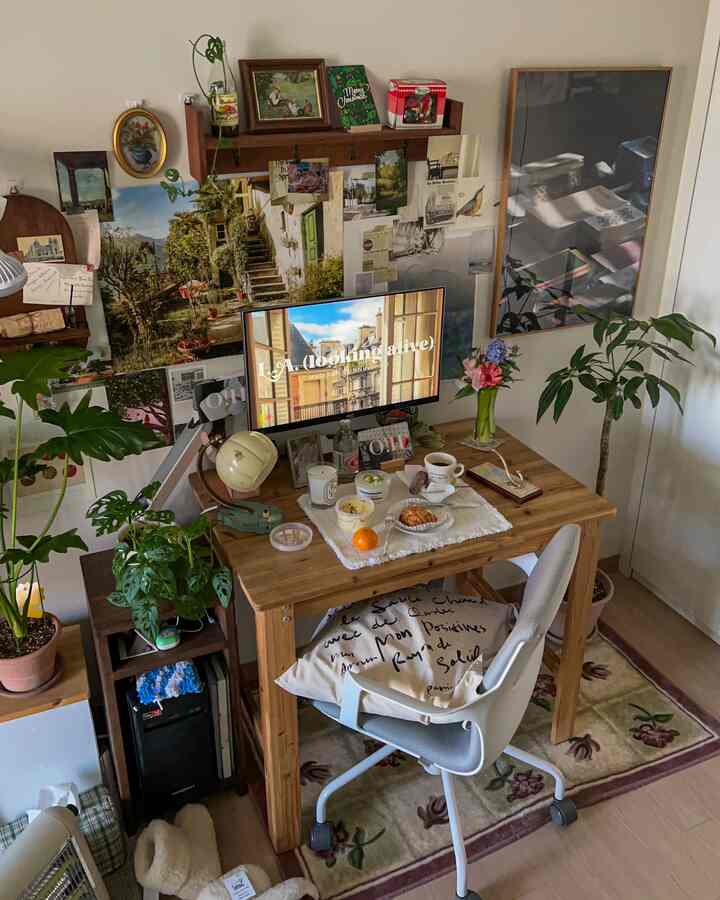 Natural wood-tone study and home cafe space featuring green plants, vintage picture frames, and a warm wall collage