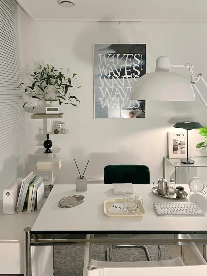 White and green toned studio apartment home office featuring mid-century modern desk and chair with a clean, simple atmosphere