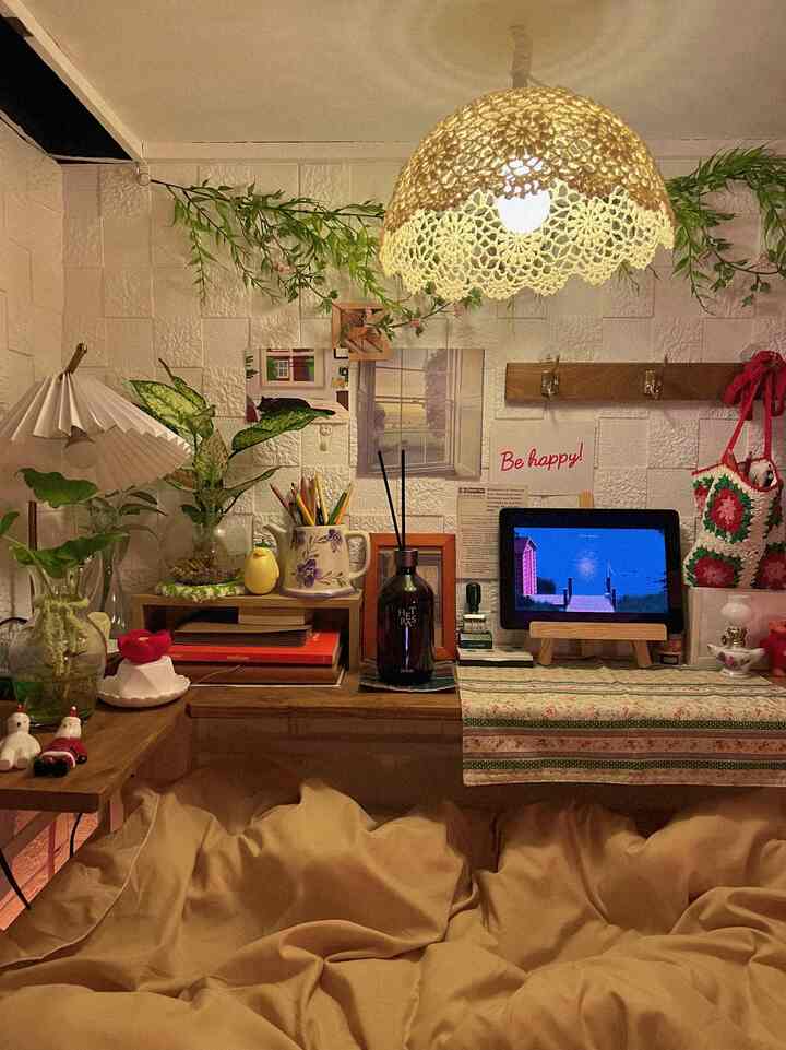 ベージュの寝具とナチュラルな木製の棚、白いテクスチャード壁と植物が配置された雰囲気のある寝室