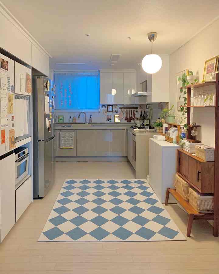 白と木目調が調和したモダンなキッチン、中央にブルーとクリーム色のチェック柄ラグが敷かれた雰囲気のあるインテリア