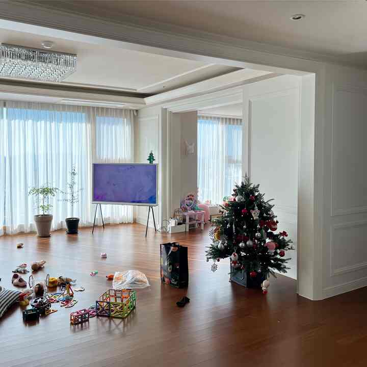 White and brown toned living room and kids' room featuring a Christmas tree with simple modern style