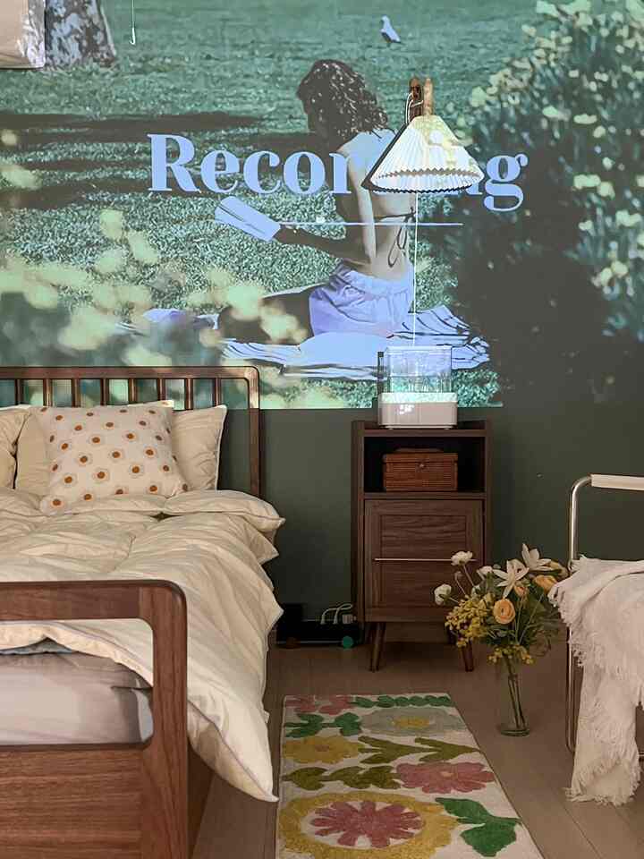 Wood tone and white bedroom featuring wooden bed, nightstand, and floral rug in a cozy atmosphere