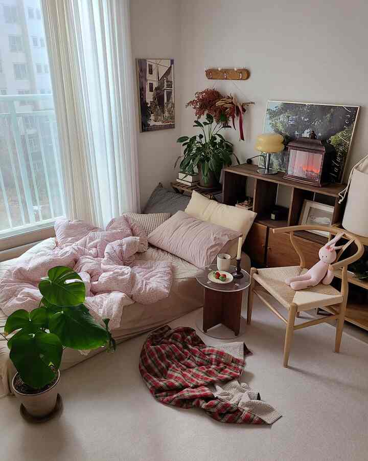 ナチュラルカラーと木製家具が配置された、ホームカフェが併設された居心地の良い寝室のインテリア