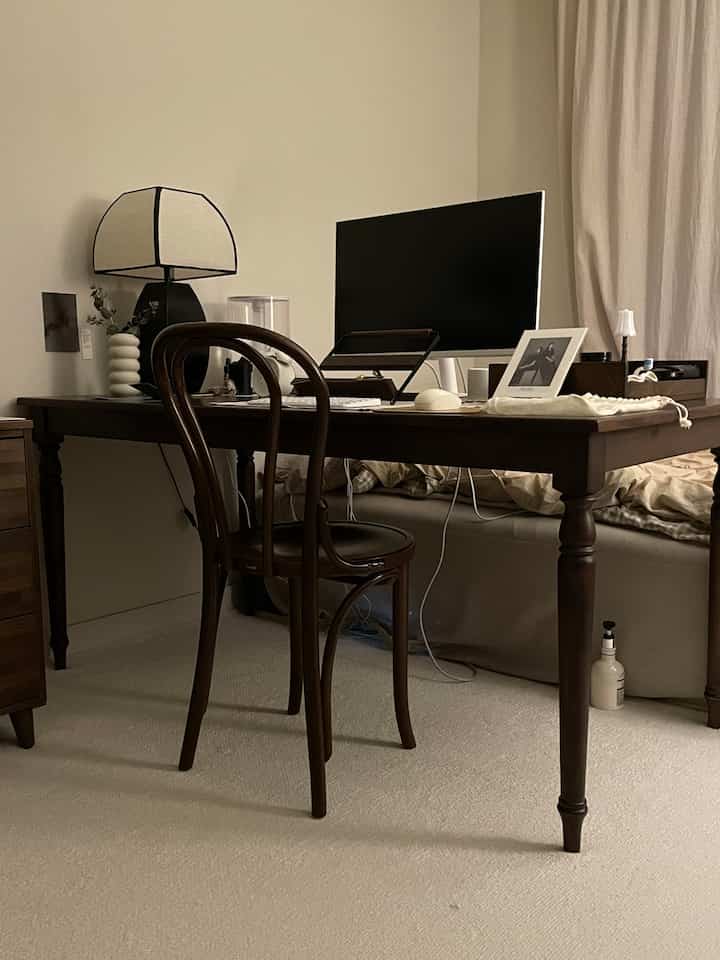 Dark brown walnut wooden desk and chair in bedroom home office setup