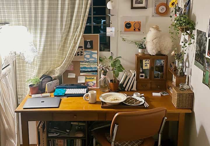 Natural warm wood tone single household desk space featuring evening meal setup and remote work atmosphere
