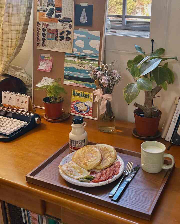 Cozy space with warm brown wood tone desk featuring home cafe style breakfast brunch setup