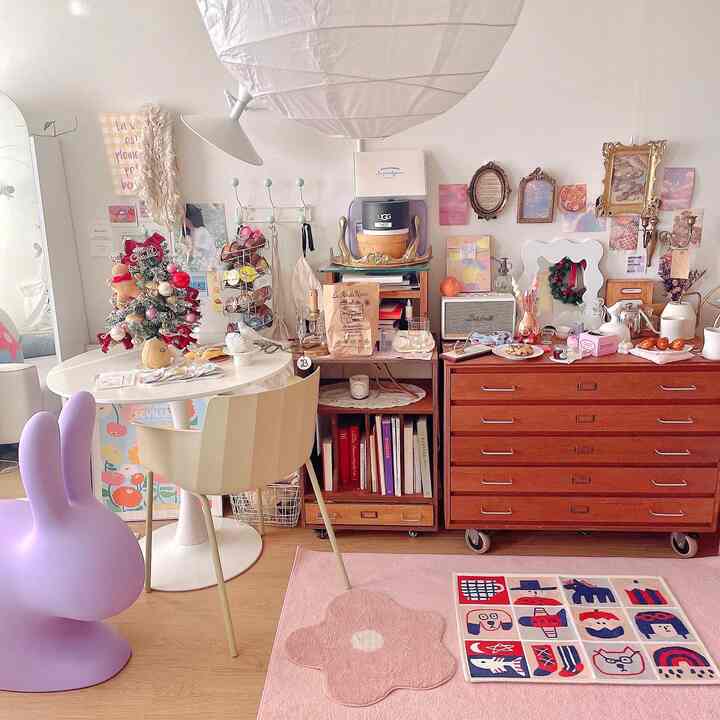 パステルカラーと木目調が調和したかわいらしいリビング、丸いダイニングテーブルと愛らしいインテリアが温かみのある空間を演出