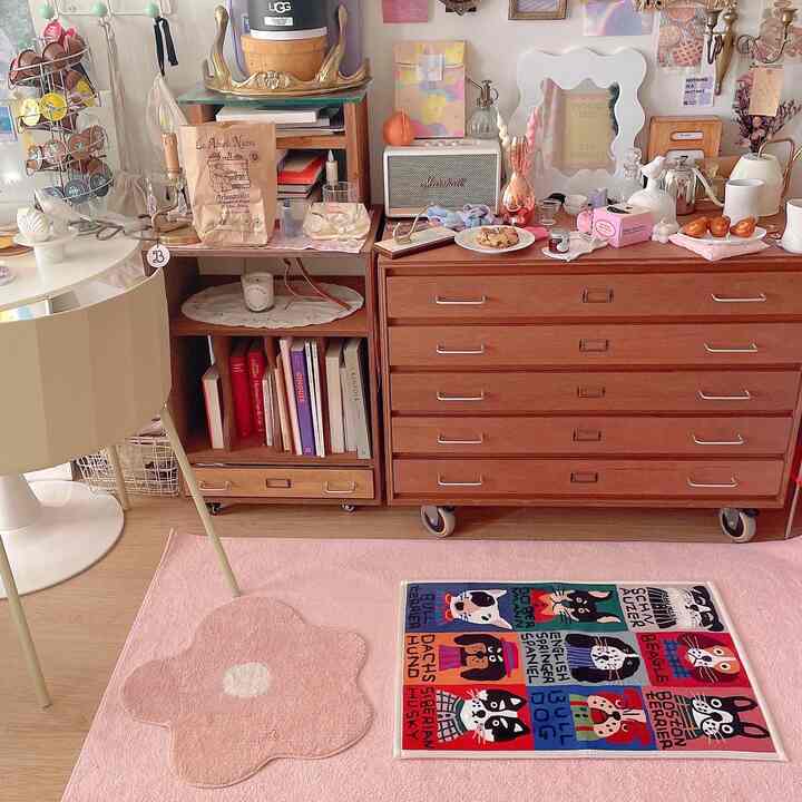 Warm wood-toned living room featuring pink rugs and various decorative accessories with cozy storage furniture arrangement