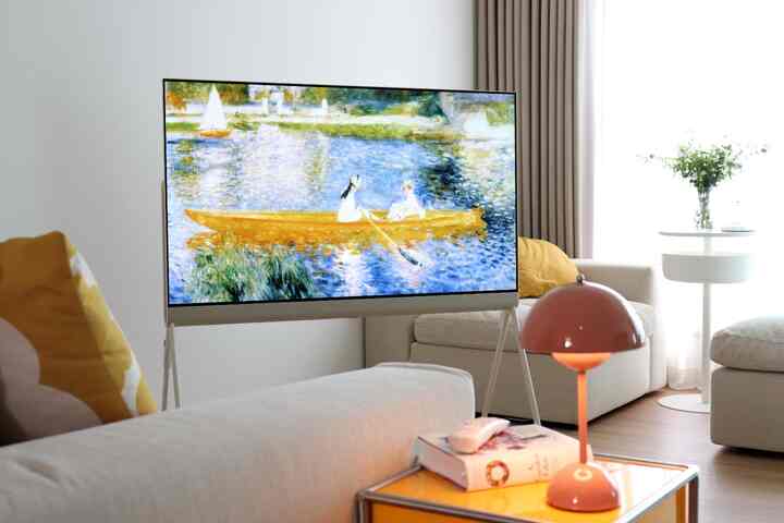 ナチュラルトーンのリビング、アイボリーのソファとLGポゼのテレビ、ピンクのテーブルランプが配置された温かみのあるインテリア