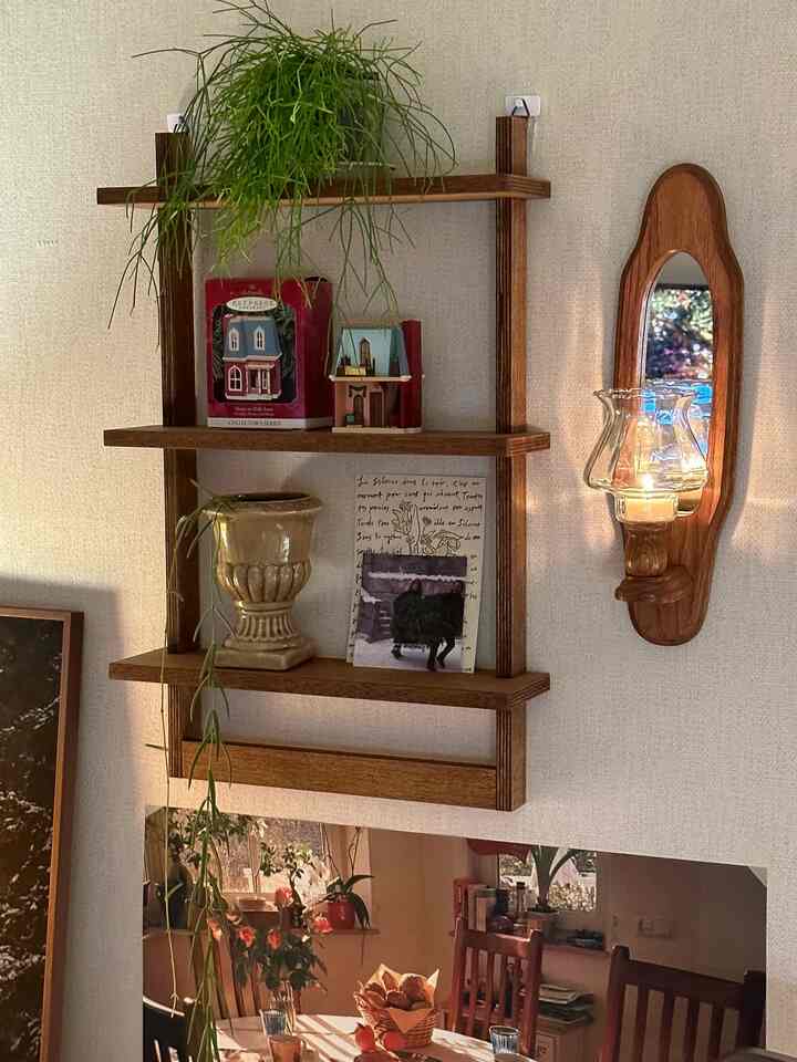 Cozy living space featuring warm wood tones with vintage style wall shelf and wall mirror candle holder