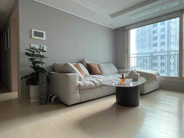 ベージュ色調のリビング、大きなソファとコーヒーテーブルが配置された自然な雰囲気のインテリア