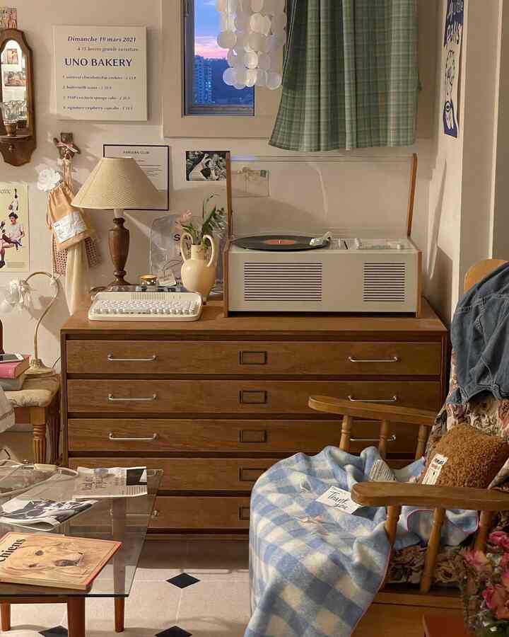 温かみのある木目調とヴィンテージ小物が調和した寝室、ターンテーブルとチェック柄のカーテンが印象的な居心地の良い空間