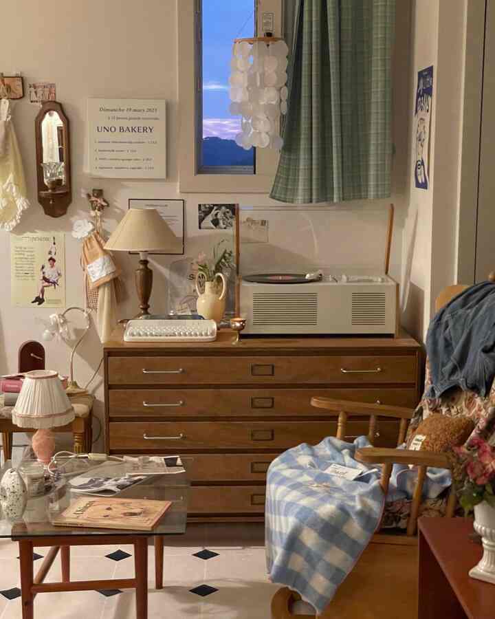 Warm wood tones with white and blue accentuate this bedroom featuring a vintage turntable and a home office setup in a cozy interior