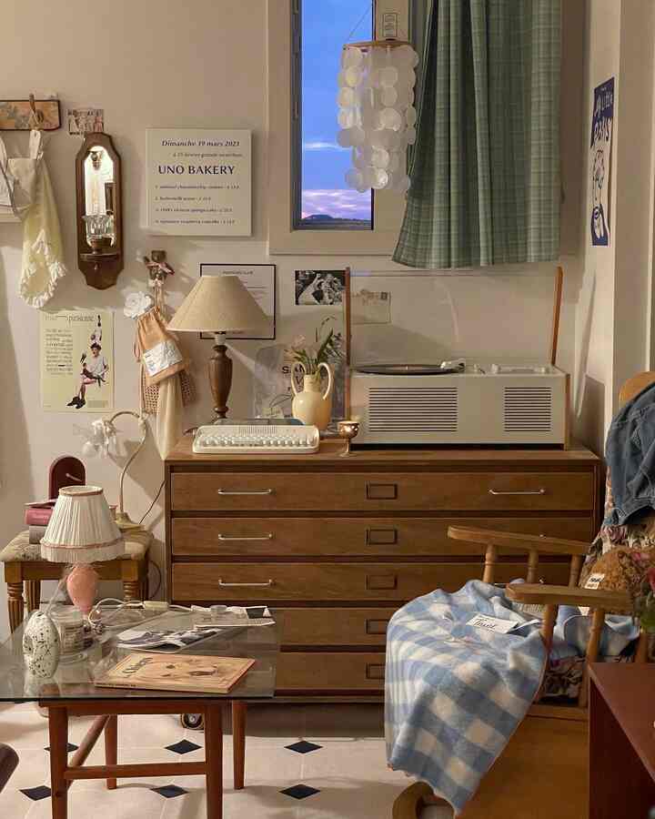 Warm wood-toned bedroom featuring vintage dresser, curtains, rug, and lighting creating a cozy interior
