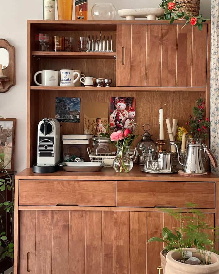 Wood tone kitchen space featuring a coffee machine, vase with flowers, and decorative items with a warm, natural atmosphere
