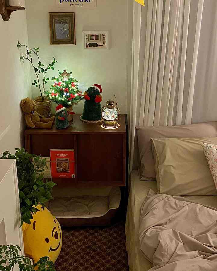 暖かいアイボリーとブラウンの色調の寝室、クリスマスの飾りとかわいいぬいぐるみが配置された居心地の良い空間