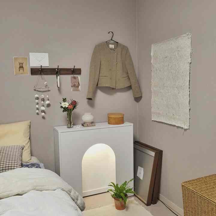 Natural color bedroom corner featuring a console table with vase, wall hanger, and cozy warm atmosphere