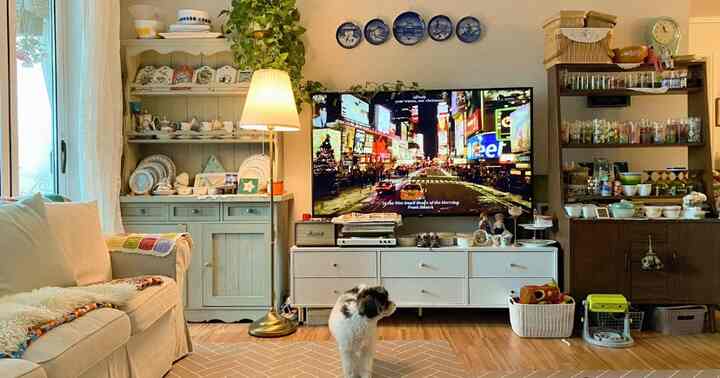 ホワイトと木目調が調和したリビング、ソファとテレビ台が配置された雰囲気のあるインテリア