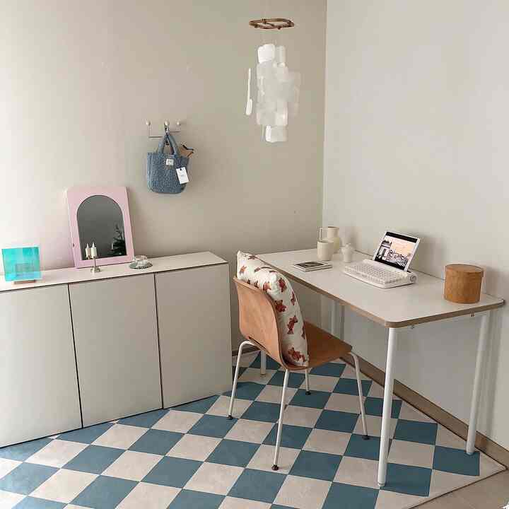 A small room in white and blue tones featuring a tidy cabinet and desk, presenting a simple and organized space