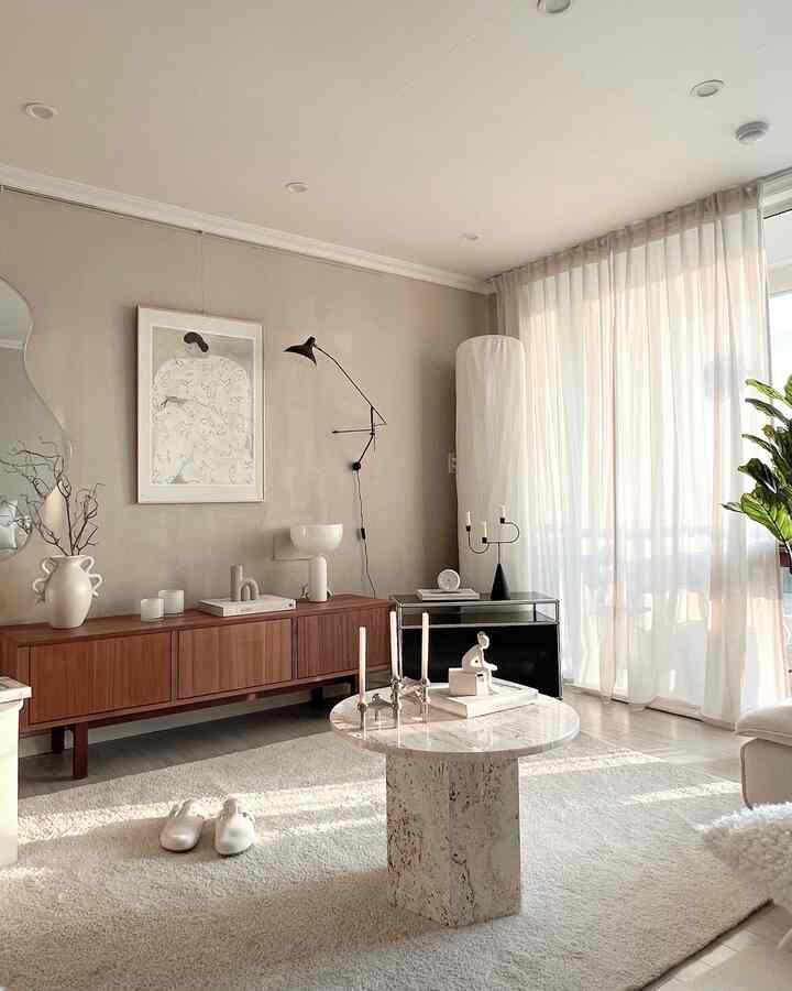 Beige and wood-toned simple Nordic living room featuring a marble coffee table and sofa bed with a cozy atmosphere