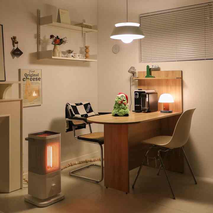Warm white-walled dining room featuring wood tone furniture, with a dining table centered with coffee machine and table lamp