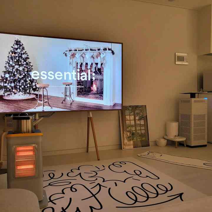 White and beige toned living room with electric heater and cat-shaped rug, creating a warm atmosphere