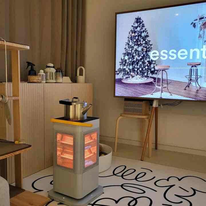 Natural beige-toned living room featuring a warm electric stove and large TV, creating a cozy winter preparation atmosphere