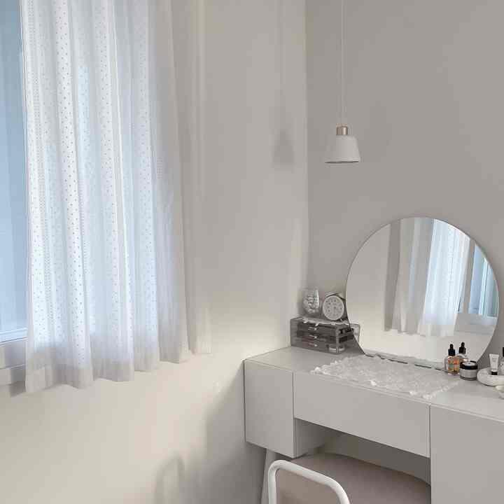白を基調としたウォークインクローゼット、化粧台とレースカーテンが配された明るいシンプルな空間