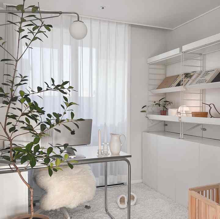 Bright home office space in white and beige tones featuring a computer desk, white office chair, and storage cabinet with a clean minimalist interior