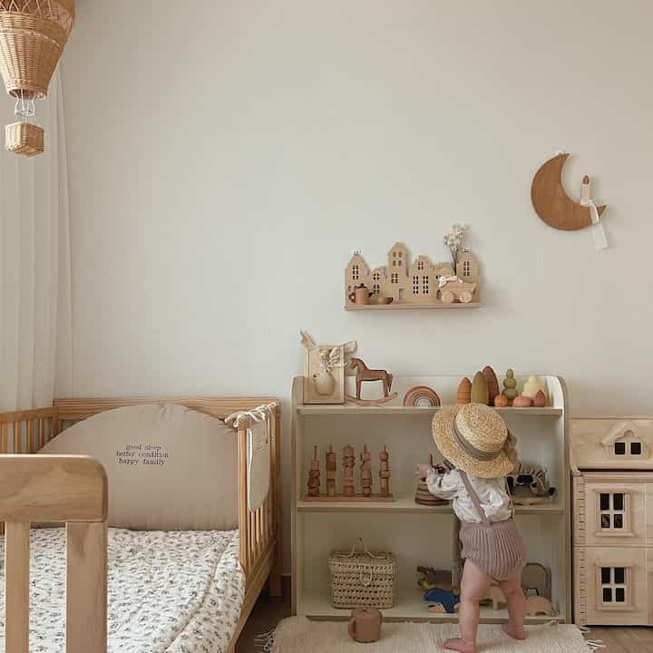 Natural color kids' room featuring wooden crib and toy storage with a warm and cozy atmosphere