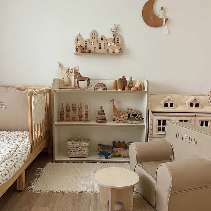 ナチュラルな木目調とホワイトが調和した子供部屋、木製のおもちゃとベビーベッドが配置された温かみのあるインテリア