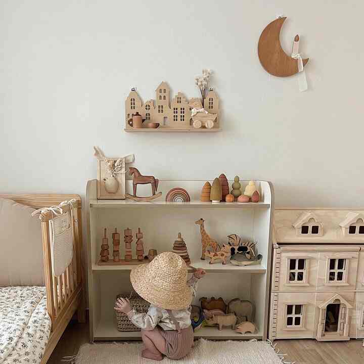 ナチュラルな色調の子供部屋、木製の知育玩具とドールハウスが配置された雰囲気のあるインテリア