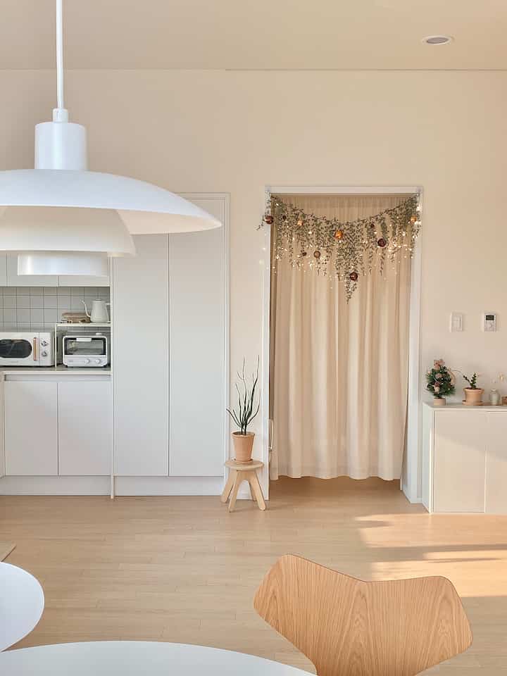 Beige and white toned kitchen space featuring curtains and dining chair with warm natural interior vibe