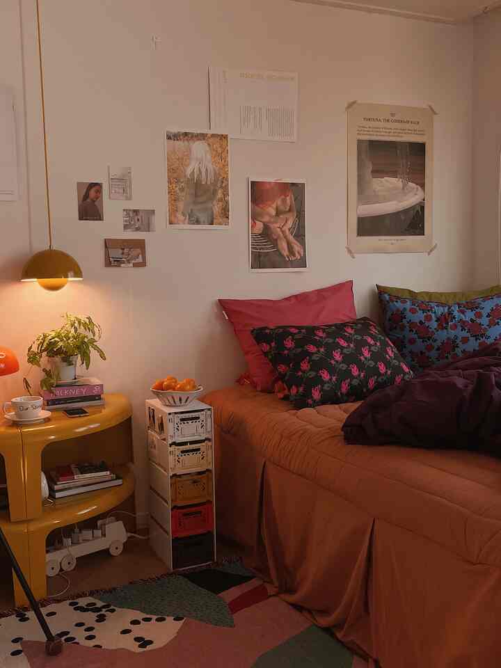 Yellow-toned bedroom with red accents featuring vintage furniture and colorful cushions creating a cozy atmosphere