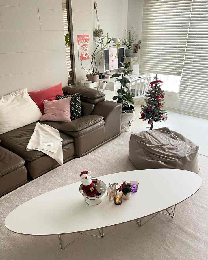 白と茶色のトーンのリビング、ソファとコーヒーテーブル、ホームオフィスが配置された雰囲気のある空間