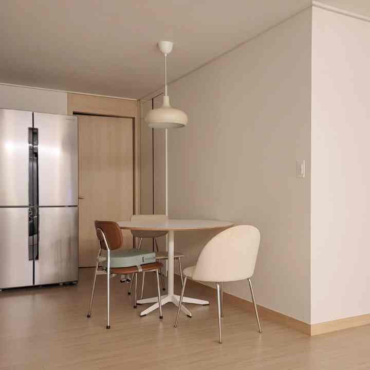 White and wood-toned kitchen space featuring a simple round dining table and chairs with a cozy atmosphere