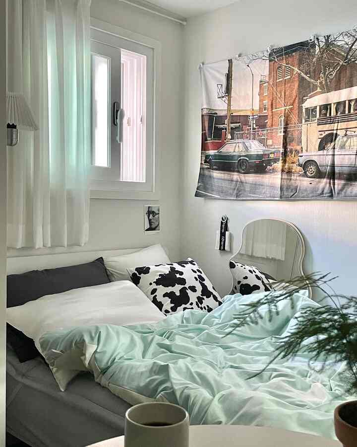 Mint and white toned studio bedroom featuring a cozy bed and clean modern interior design