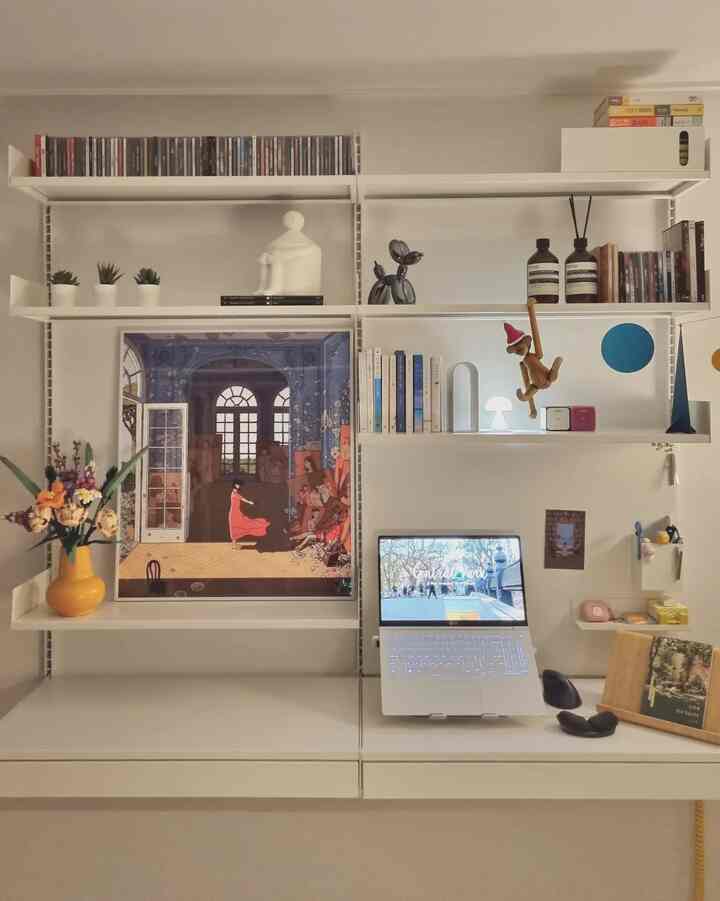 Natural color small room featuring desk, picture frame, and decorative objects on shelves in a modern home office