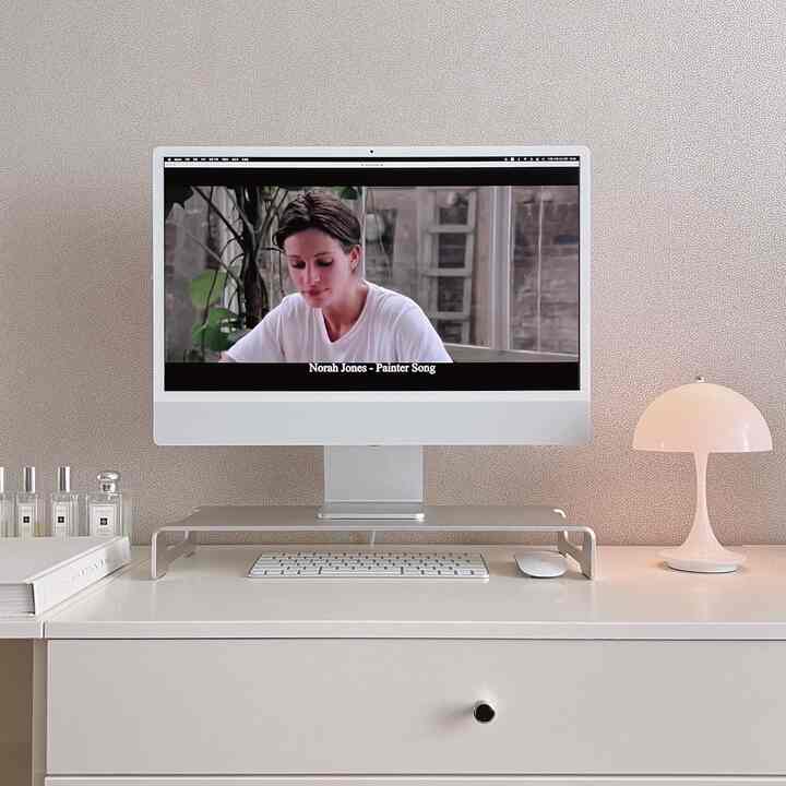 Clean white tone home office space featuring Apple iMac and monitor stand arranged on a simple desk setup with minimalist style