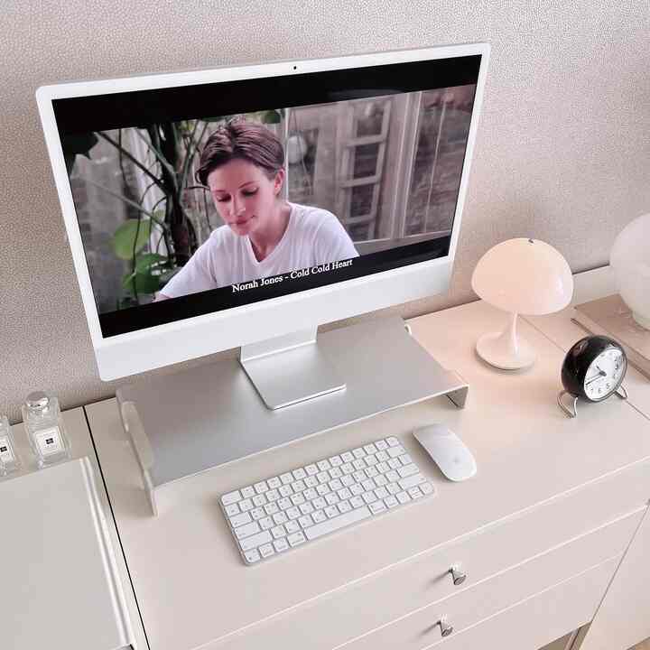 White and silver-toned home office space featuring an Apple iMac and desk in a clean, simple modern style