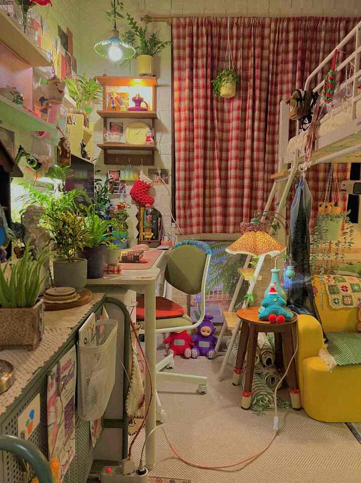 Narrow two-person bedroom with red check curtains and natural plants, featuring a remote work setup and bunk bed