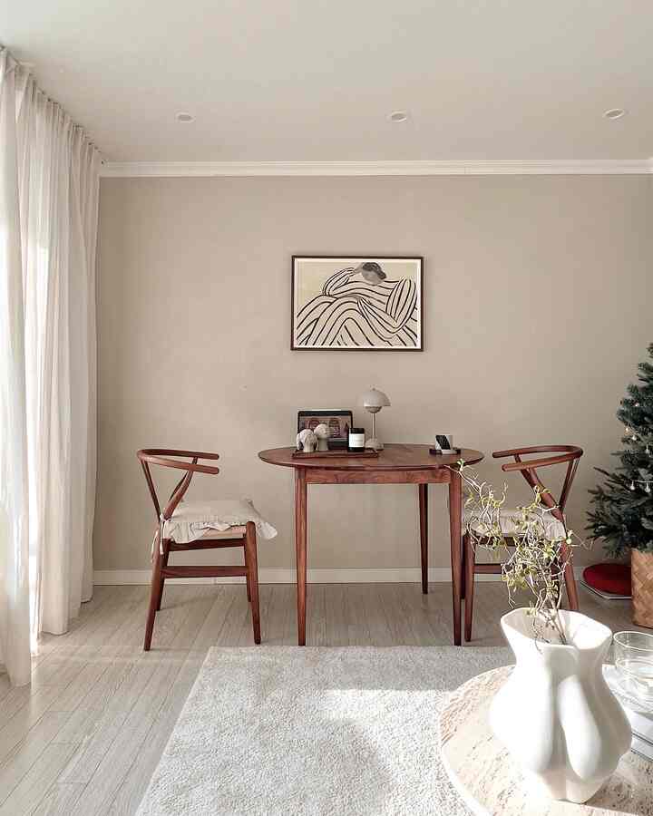 Beige-toned wall with wooden table and chairs in a natural modern styled cozy living room space