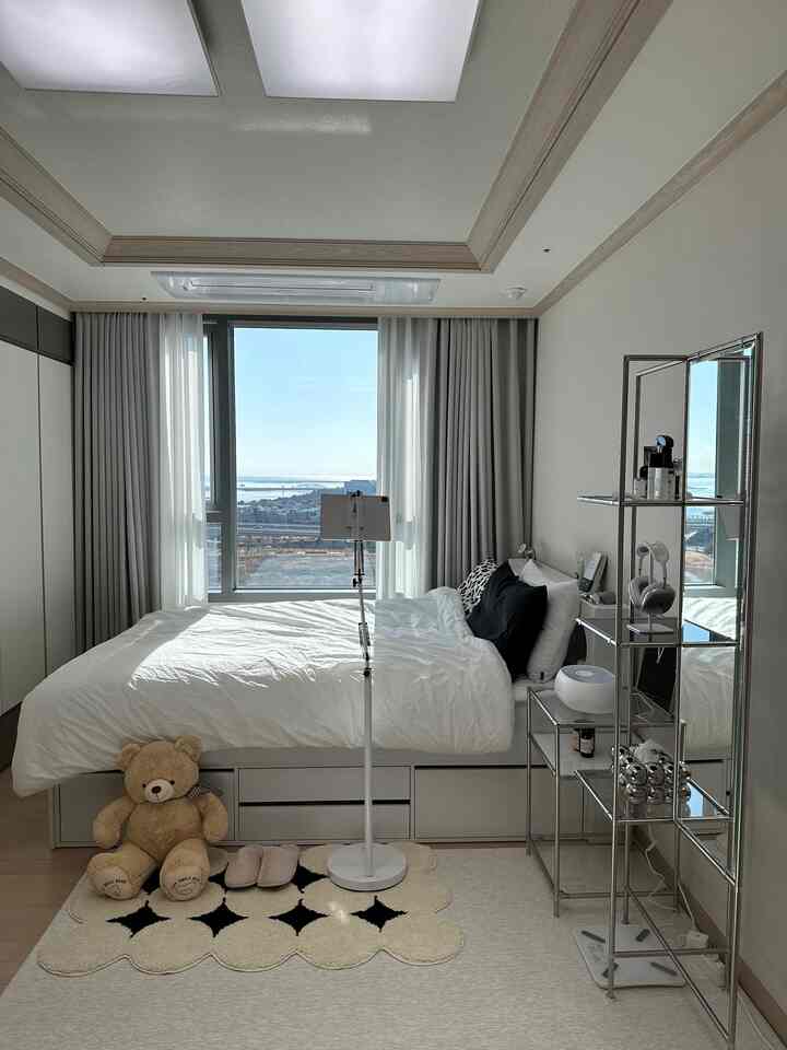 白黒のトーンの寝室、ベッドとナイトテーブル、ラグが整然と配置されたモダンでシンプルなインテリア