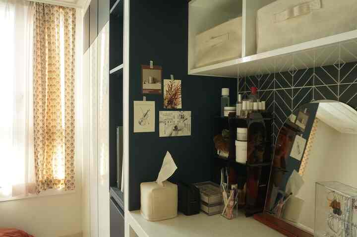 ベージュとネイビーのトーンの寝室、カーテンと化粧台が配置された雰囲気のある自然な空間