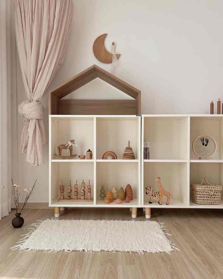 ベージュとホワイトの木目調のベビールーム、棚とおもちゃが配置された雰囲気のあるインテリア