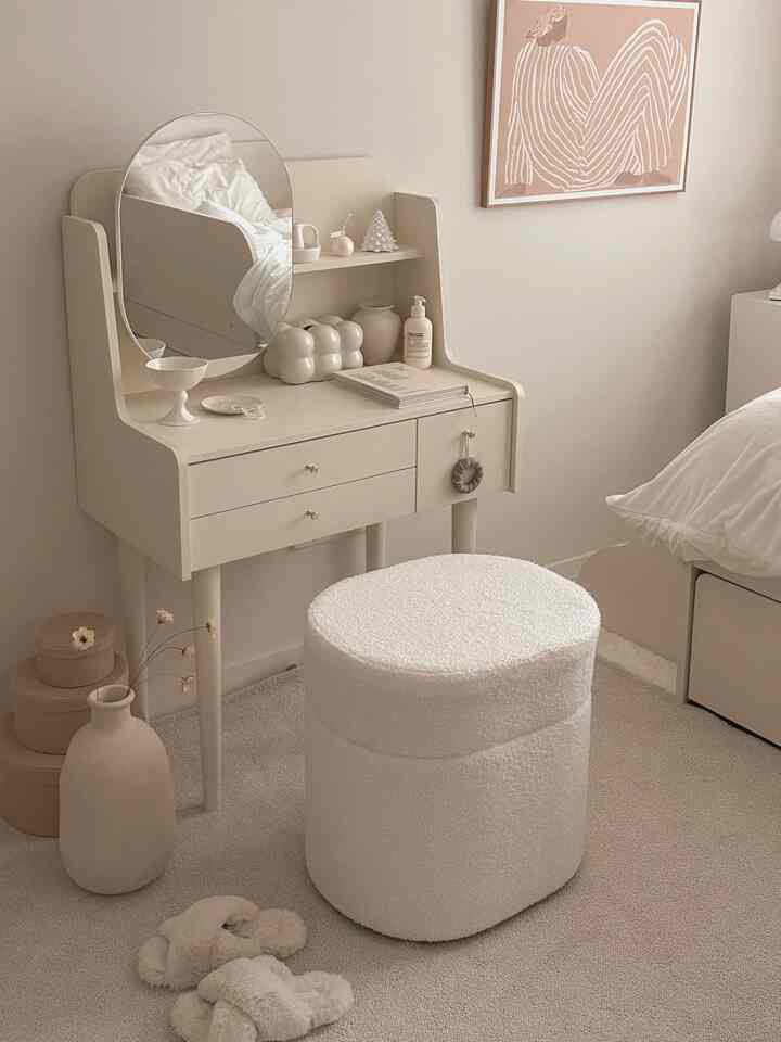 Warm beige and ivory toned powder room featuring a vanity and boucle stool, creating a feminine and cozy atmosphere
