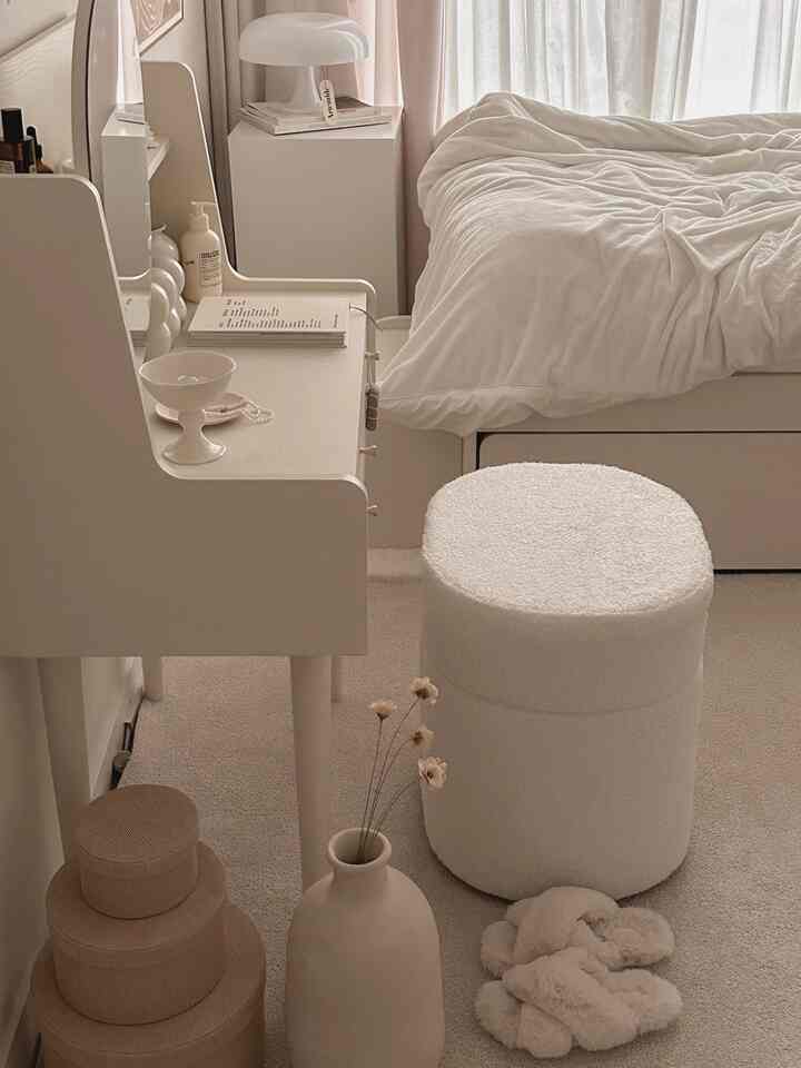 柔らかな白とベージュのトーンの寝室、化粧台とふわふわのスツールが配置された落ち着いた印象的な空間