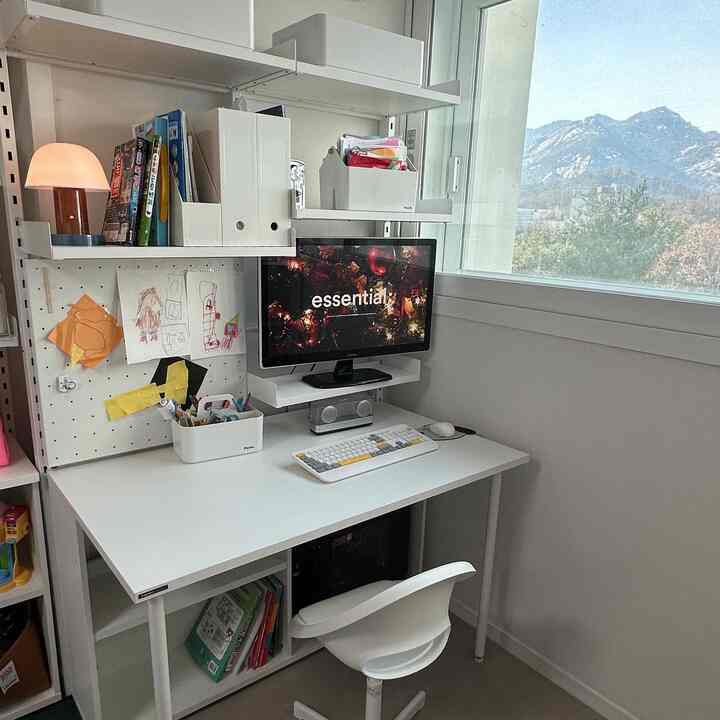 白を基調としたコンパクトなホームオフィス、机と椅子、窓が調和した清潔感あるインテリア