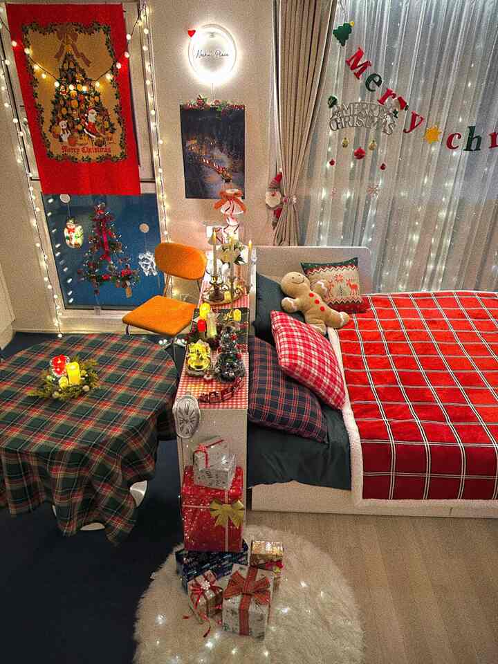 Red and green toned studio bedroom featuring Christmas decorations and string lights creating a warm winter atmosphere