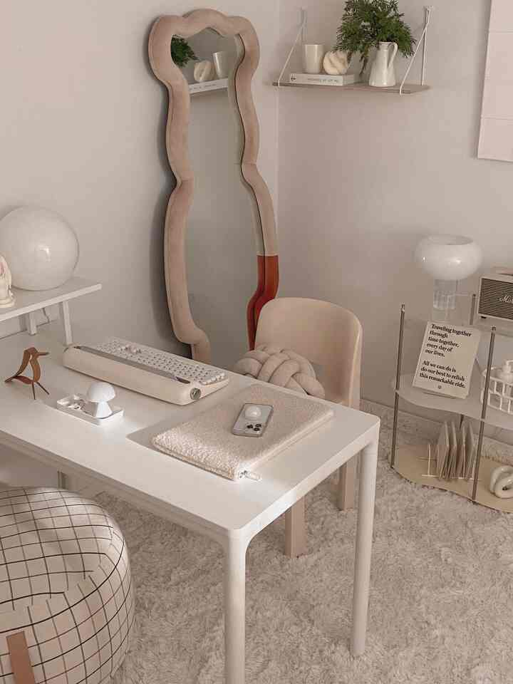 白とベージュの色調の書斎、すっきりとしたデスクと椅子、全身鏡、かわいらしいオブジェが配置された雰囲気のあるインテリア